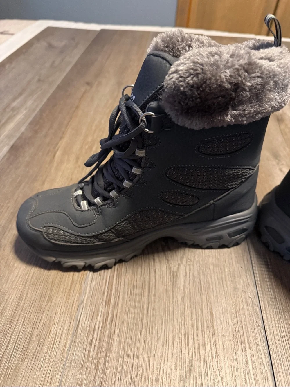 Skechers D'Lites Bomb Cyclone winter boots in a charcoal color, featuring a faux